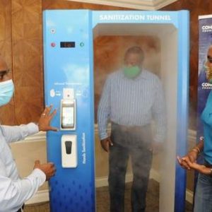 Adriel McKay (left), Founder and Managing Director of Concept Promotions, demonstrates the use of the 360-Degree Sanitization Tunnel to Phillip Burke-Green (centre), Security Supervisor at Sagicor Group Jamaica and Jacqueline Donaldson, Vice President, Human Resources and Corporate Services of Sagicor Group Jamaica during an exercise to showcase the use of the device.